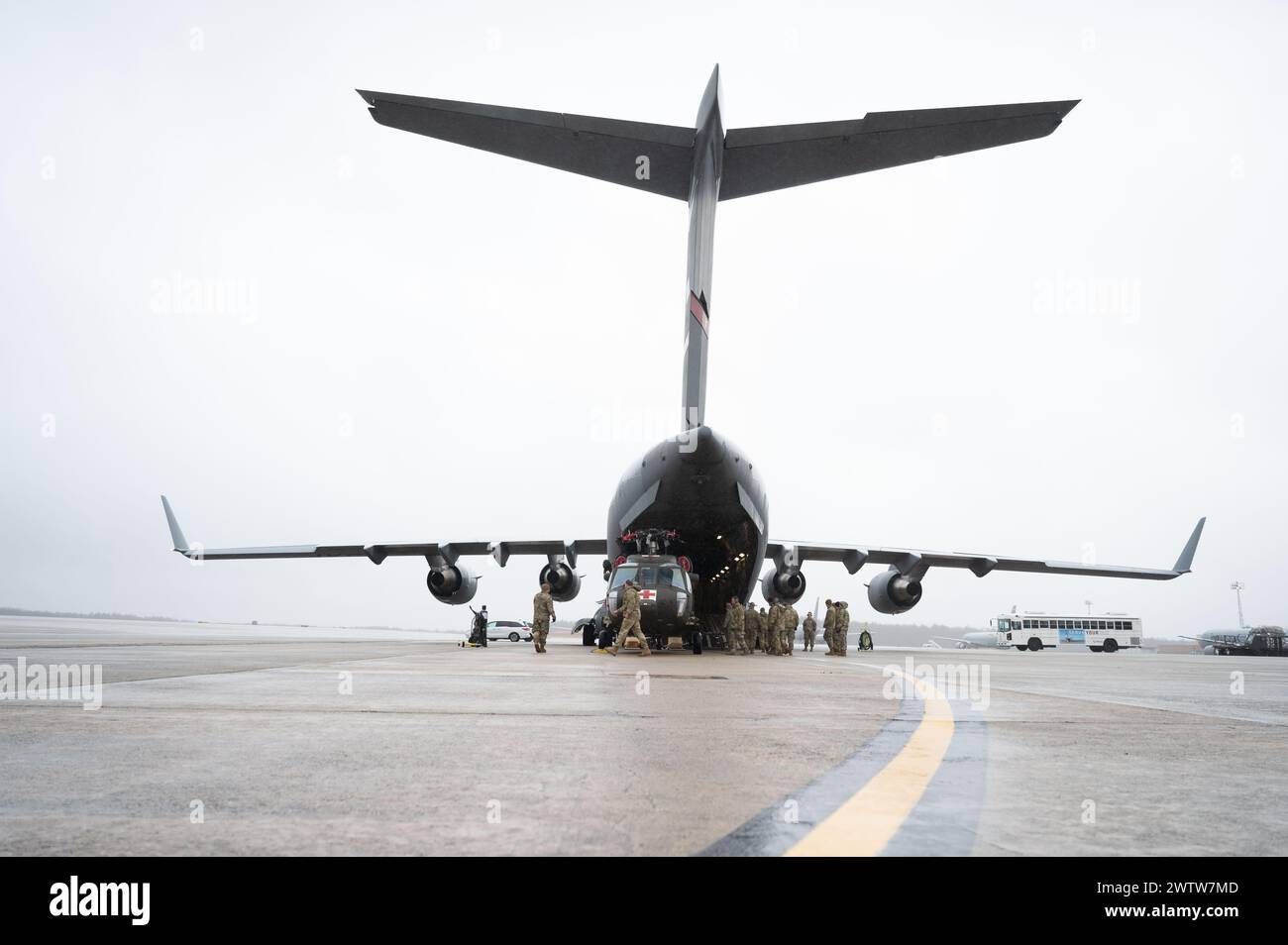 Des soldats et des aviateurs de la 157th Air ravitaillement Wing, de la 238th Medevac Company et de la 167th Airlift Wing, chargent deux Black Hawks pour l'exercice Granite Falco dans un C-17 Globemaster III le 15 mars 2024, à la Pease Air National Guard base, New Hampshire. Au cours de cet exercice de quatre semaines, les équipes doivent effectuer des missions de vol simulées à bord de deux hélicoptères Black Hawk et dispenser une formation médicale de base au personnel militaire et aux premiers intervenants de Cabo Verdean. (Photo de la U.S. Air National Guard par Tech. Sgt. Victoria Nelson) Banque D'Images