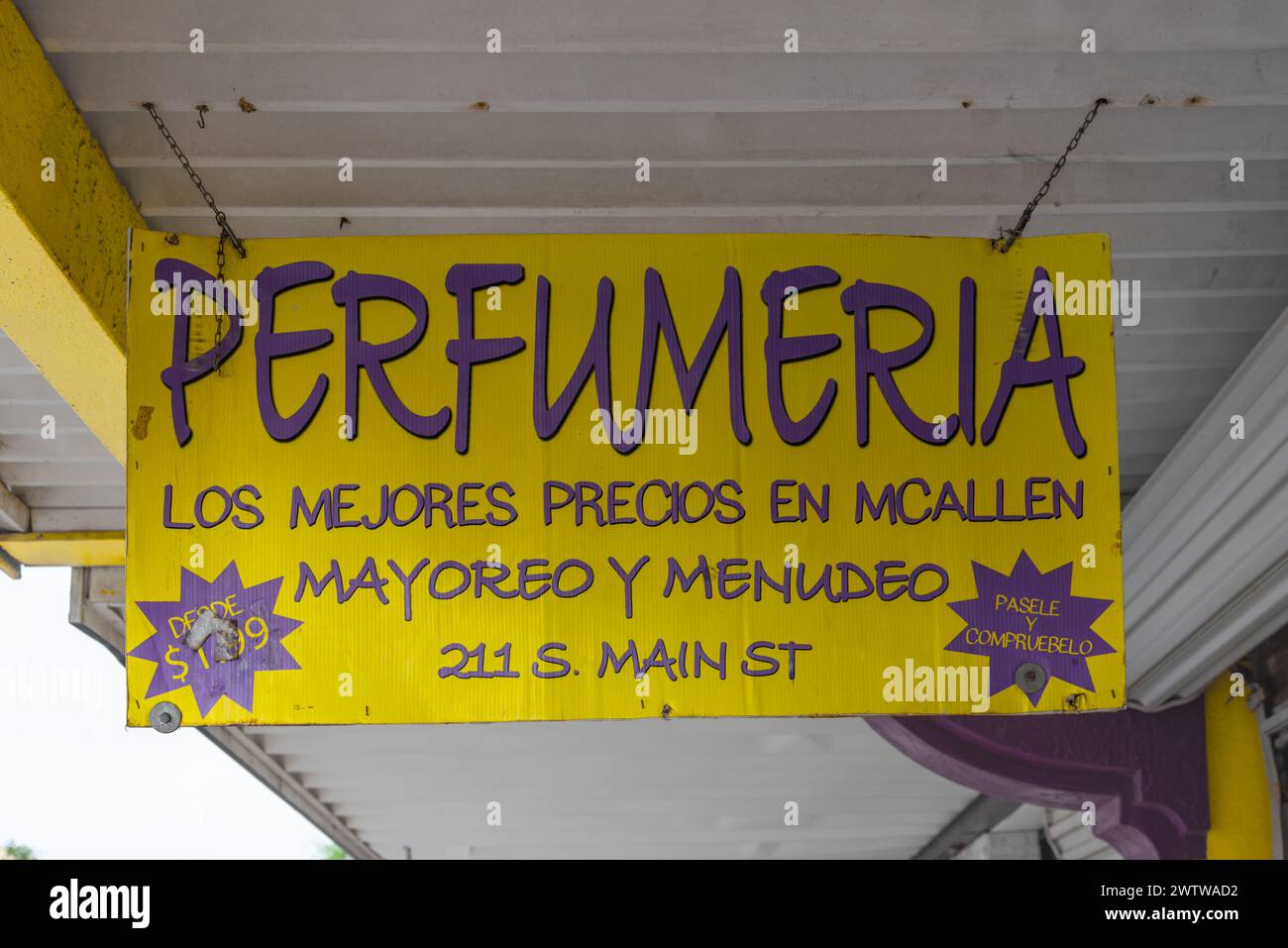 Panneau en carton suspendu jaune et violet pour Perfumeria, magasin de gros et de détail, McAllen, comté de Hidalgo, Texas, États-Unis. Banque D'Images