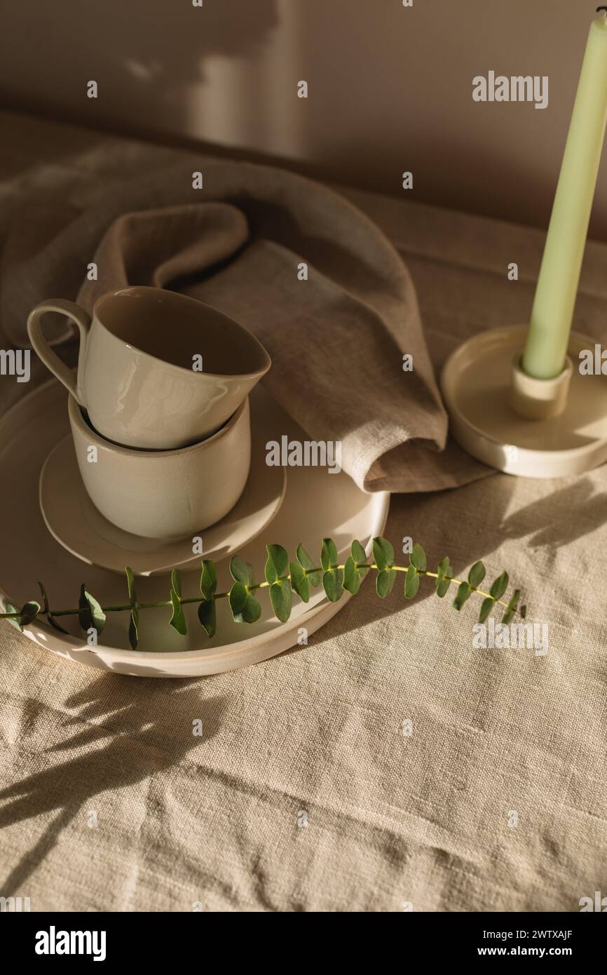 Vue aérienne d'une bougie et d'un assortiment de céramiques sur une table en plein soleil Banque D'Images