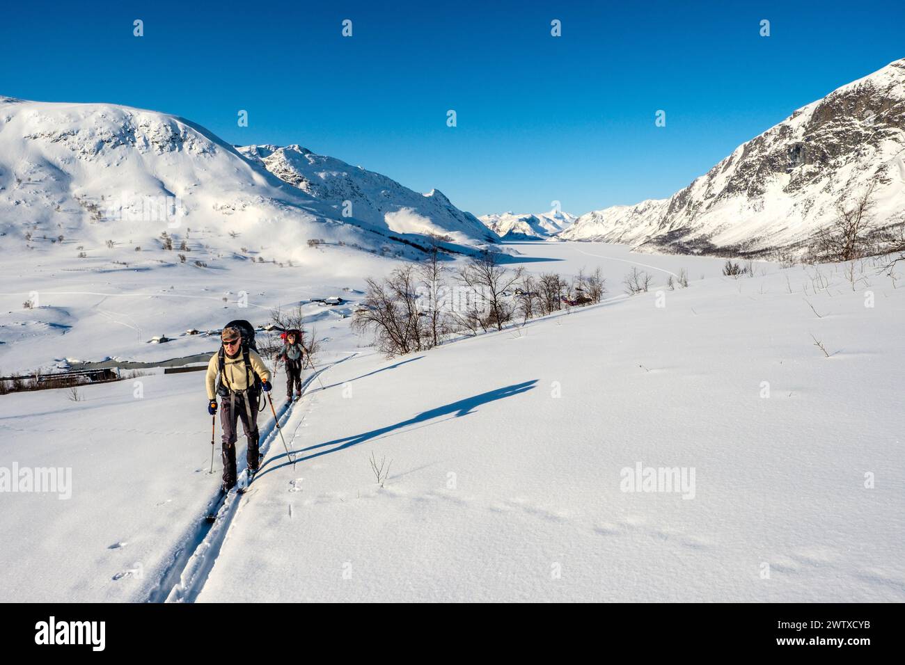 Deux skieurs partent de Gjendesheim DNT Cabin dans la région de Jotunheim en Norvège, l'hiver Banque D'Images