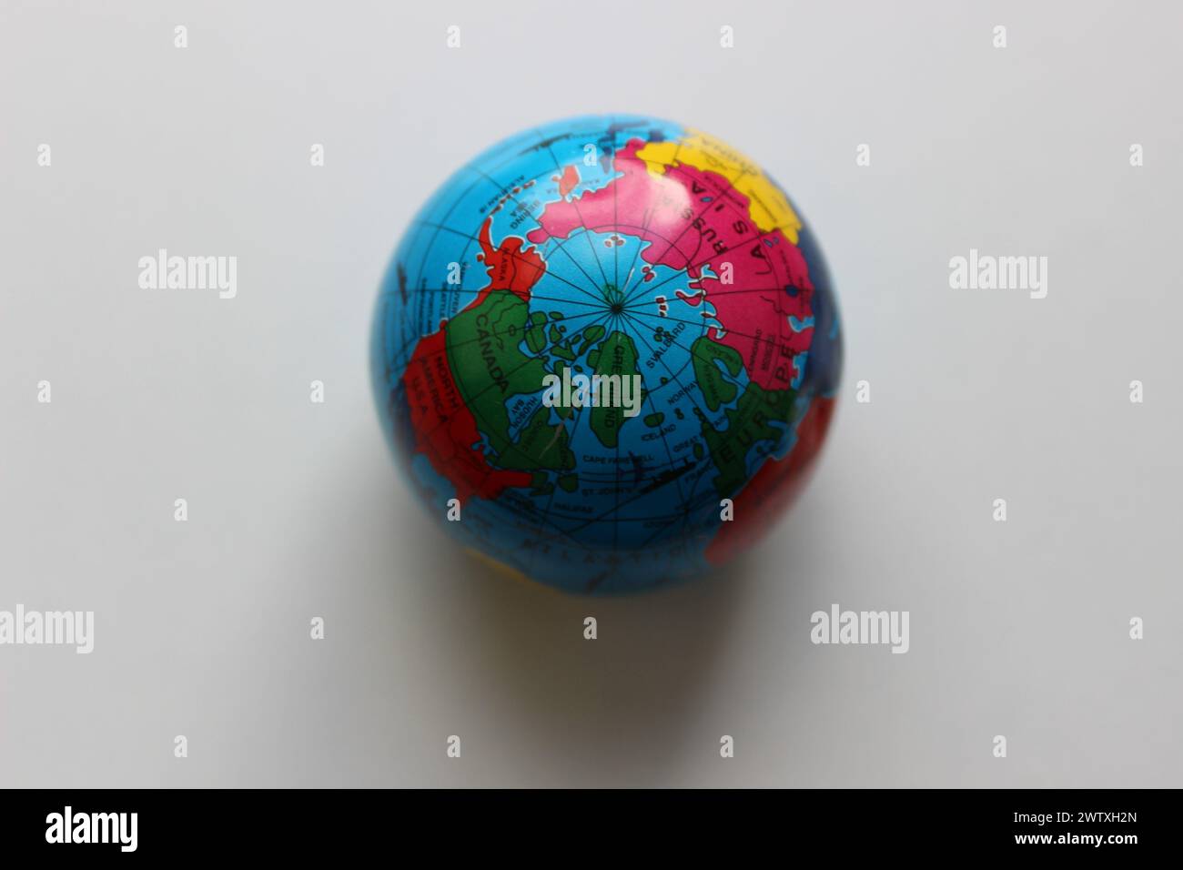 Vue de dessus du pôle Nord sur un globe terrestre miniature sur une surface blanche Banque D'Images