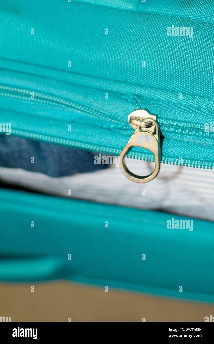 Valise bleue pleine de vêtements, indiquant la préparation du voyage. Banque D'Images