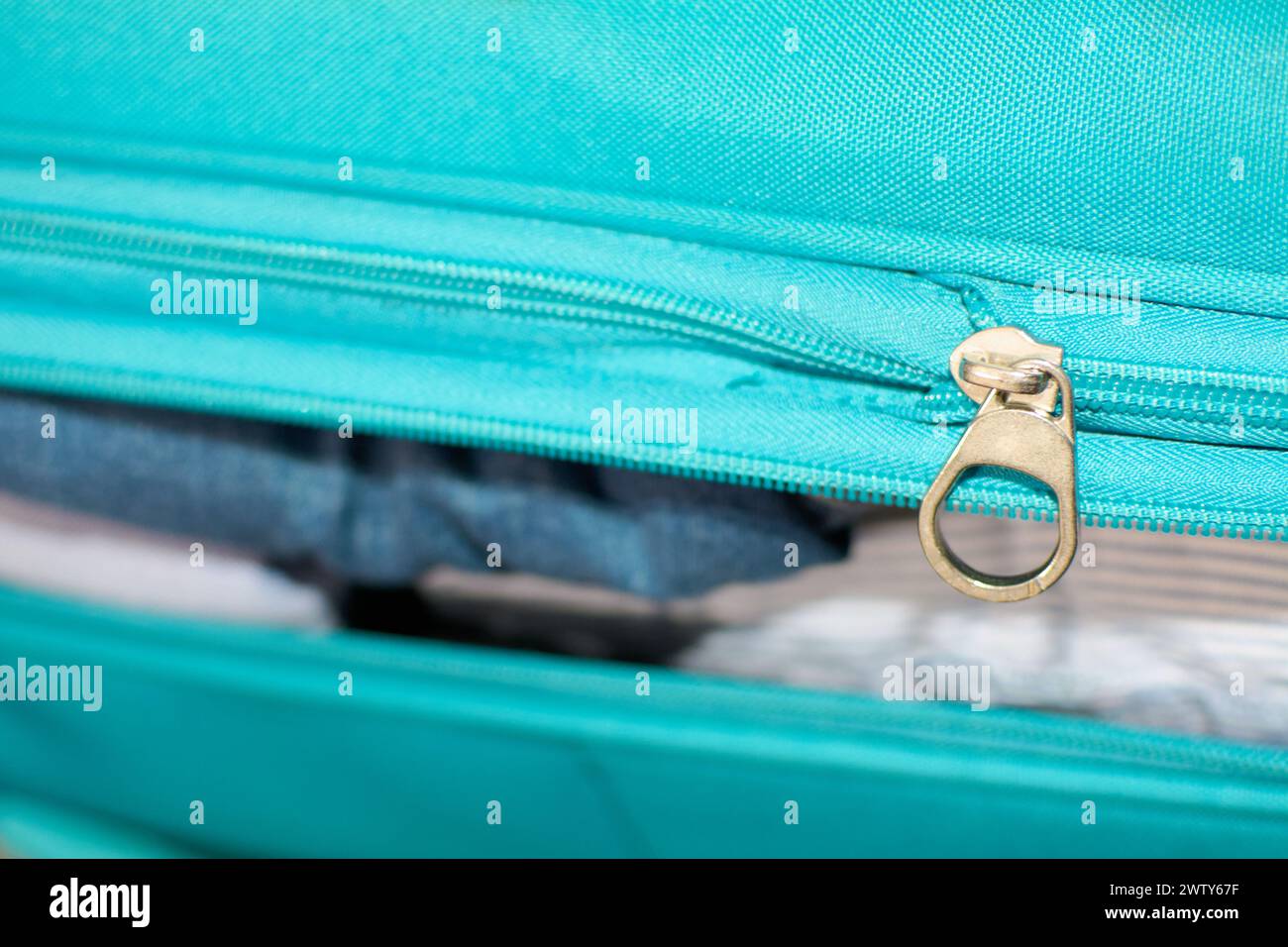 Valise bleue pleine de vêtements pour le voyage Banque D'Images