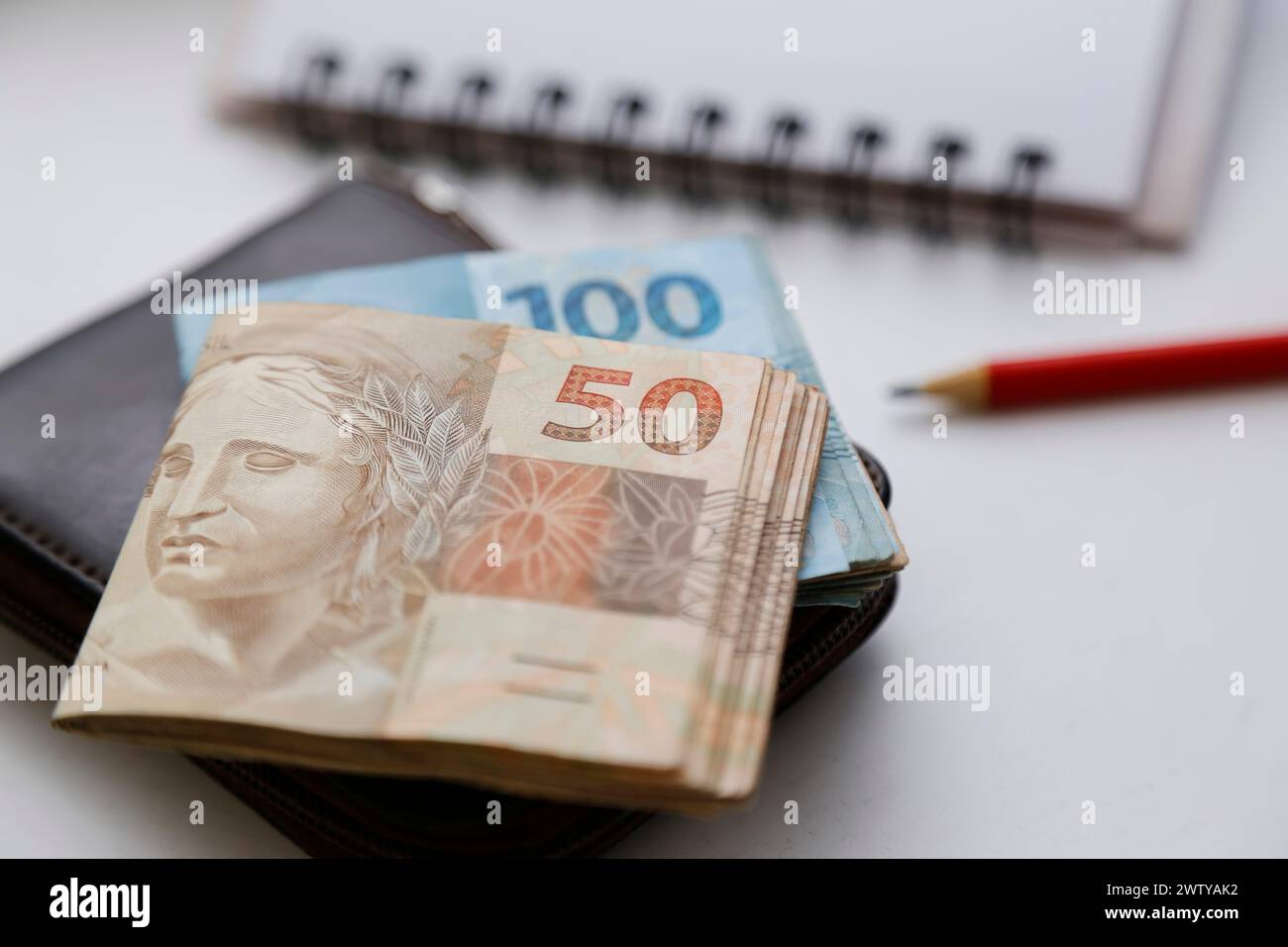 Plusieurs reais notes - argent du Brésil sur la table et portefeuille, crayon et bloc-notes Banque D'Images