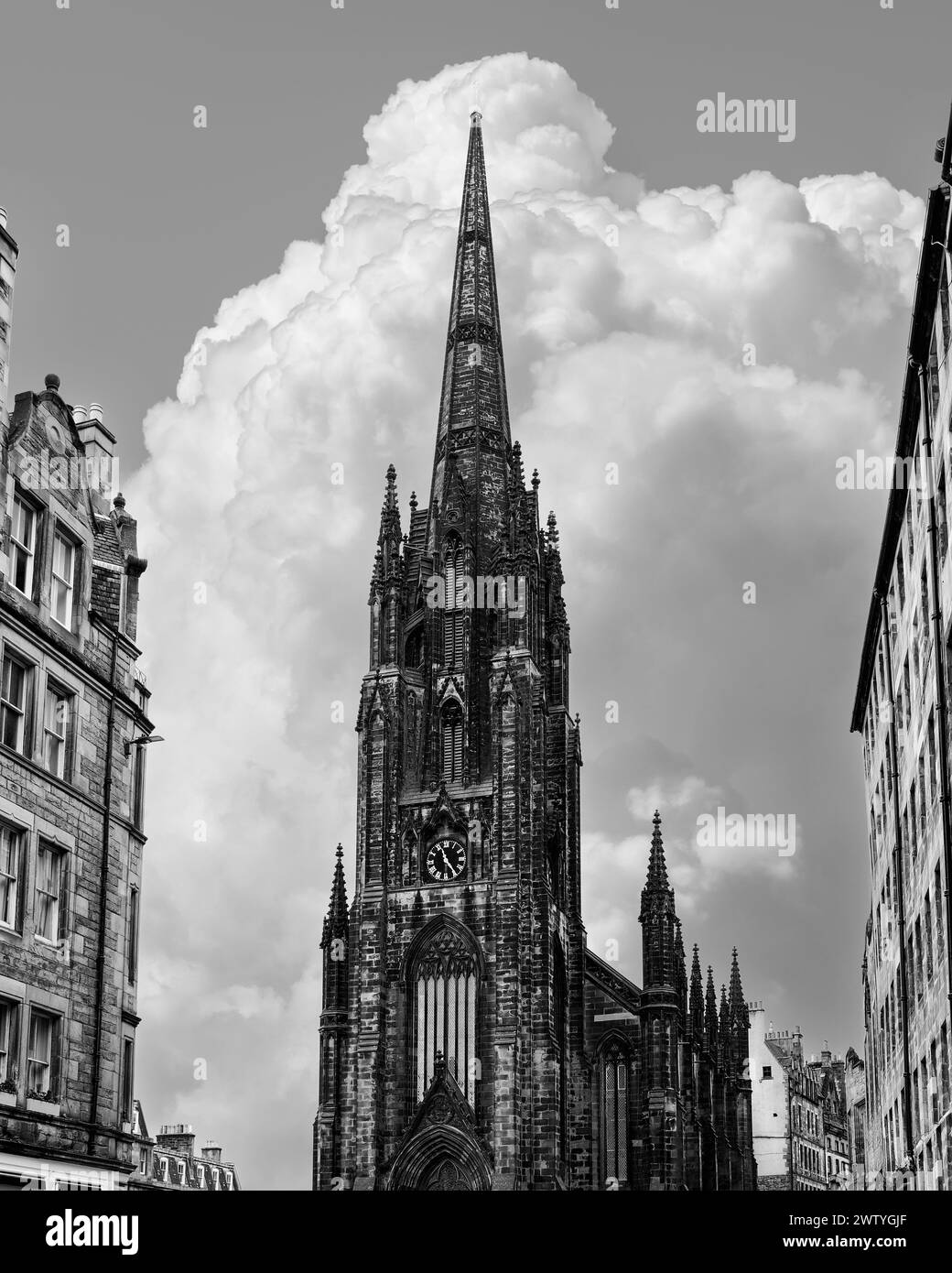 Capture en noir et blanc de l'horizon d'Édimbourg dominé par l'imposante flèche gothique Hub, parfaitement alignée avec les nuages de cumulus montants Banque D'Images