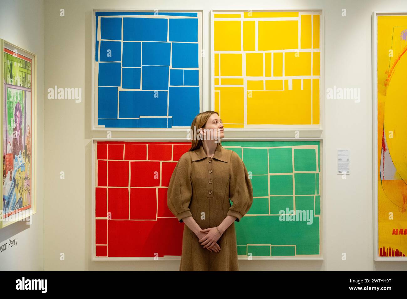 Londres, Royaume-Uni. 20 mars 2024. Un membre du personnel avec des œuvres de la série 'lustrations IV' de Christopher le Brun sur les Editions Manifold stand à l'avant-première de la London original Print Fair à Somerset House. Des œuvres de six siècles de gravure, réalisées par des artistes bien connus et émergents, sont exposées dans la plus ancienne foire d’art de la capitale et la plus ancienne foire spécialisée de l’impression au monde. La foire se déroule du 21 au 24 mars. Credit : Stephen Chung / Alamy Live News Banque D'Images