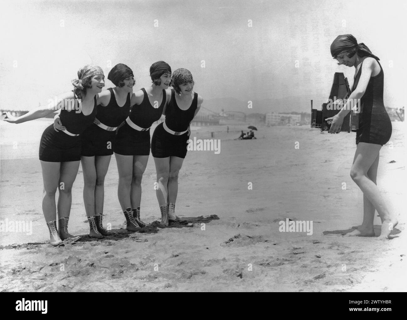Quatre des « beautés de baignade » de Mack Sennett en costumes One Piece sont photographiées par un cinquième sur la plage Banque D'Images