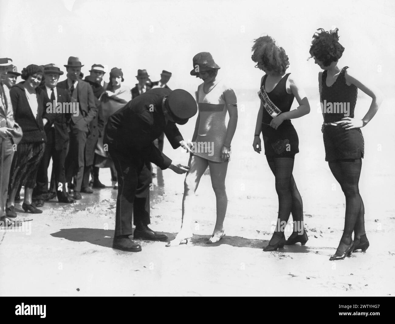Foule rassemble alors qu'un policier mesure la longueur d'un maillot de bain d'une femme sur la plage d'Atlantic City, New Jersey Banque D'Images