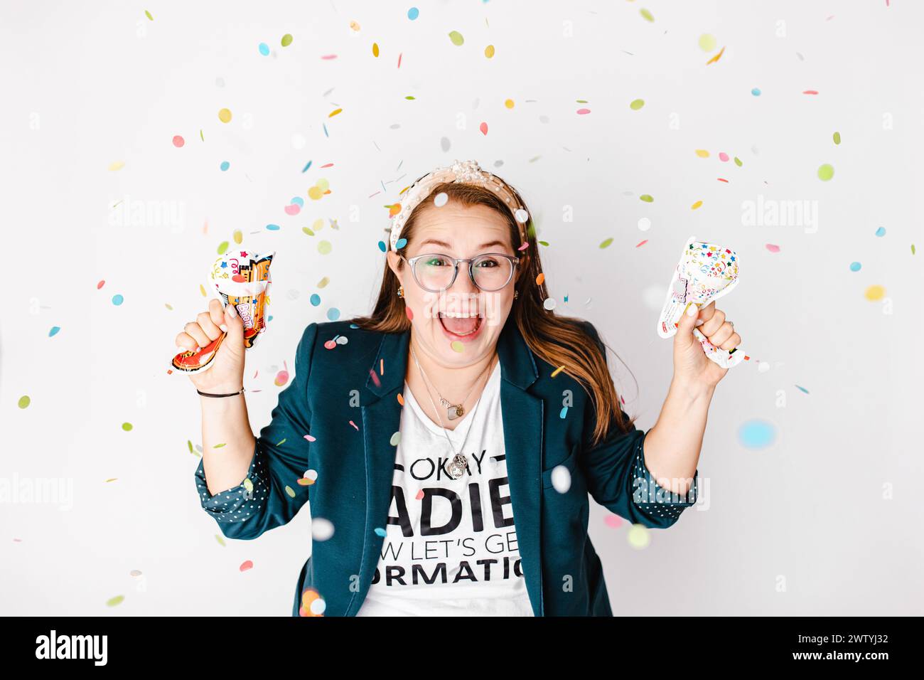 Femme célébrant avec des poppers de confettis. Banque D'Images