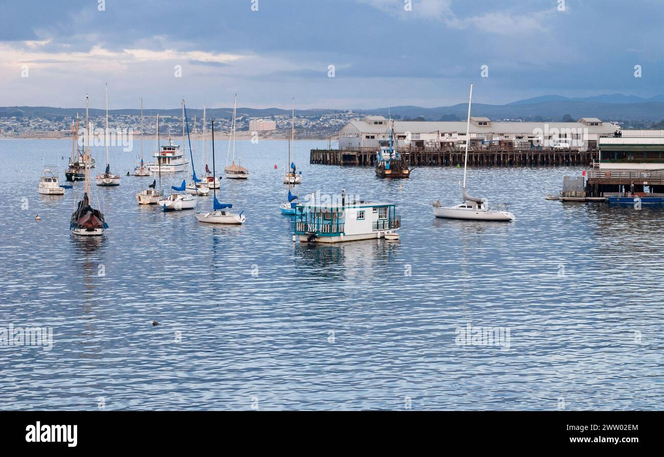 Bateaux ancrés dans l'eau calme au port de Monterey par une journée couverte au coucher du soleil sur la côte californienne. Banque D'Images
