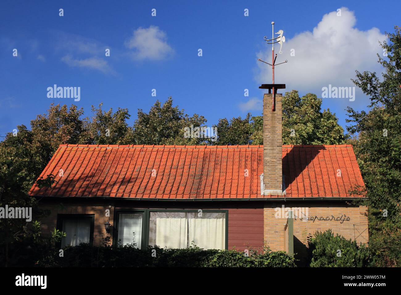 Jolie petite maison, construite en brique rouge, ciel bleu en arrière-plan Banque D'Images