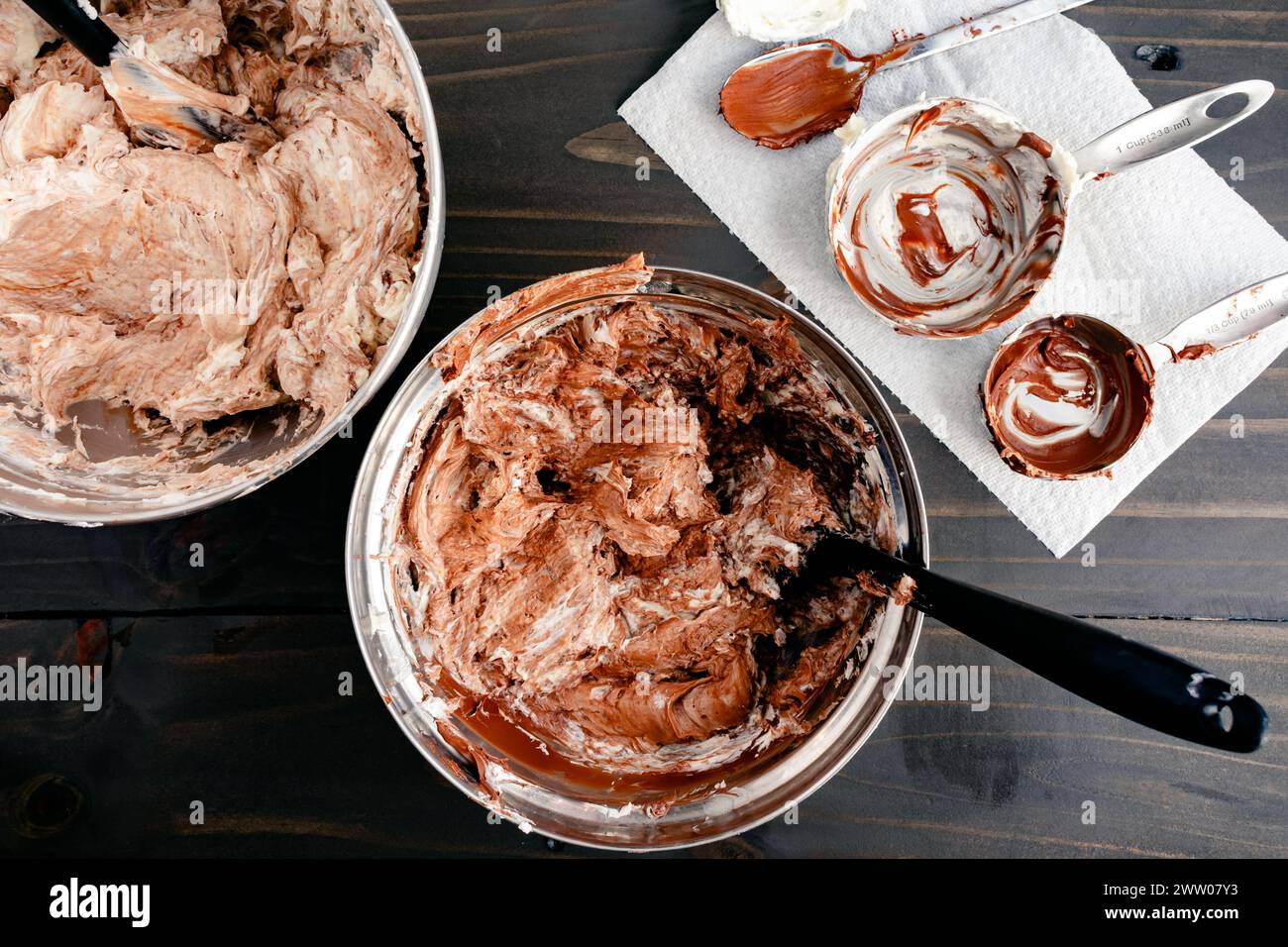 Meringue suisse à la vanille crème au beurre mélangée à de la tartinade noisette-cacao : deux bols à mélanger remplis de glaçage à la vanille mélangés à de la crème de noisette Banque D'Images