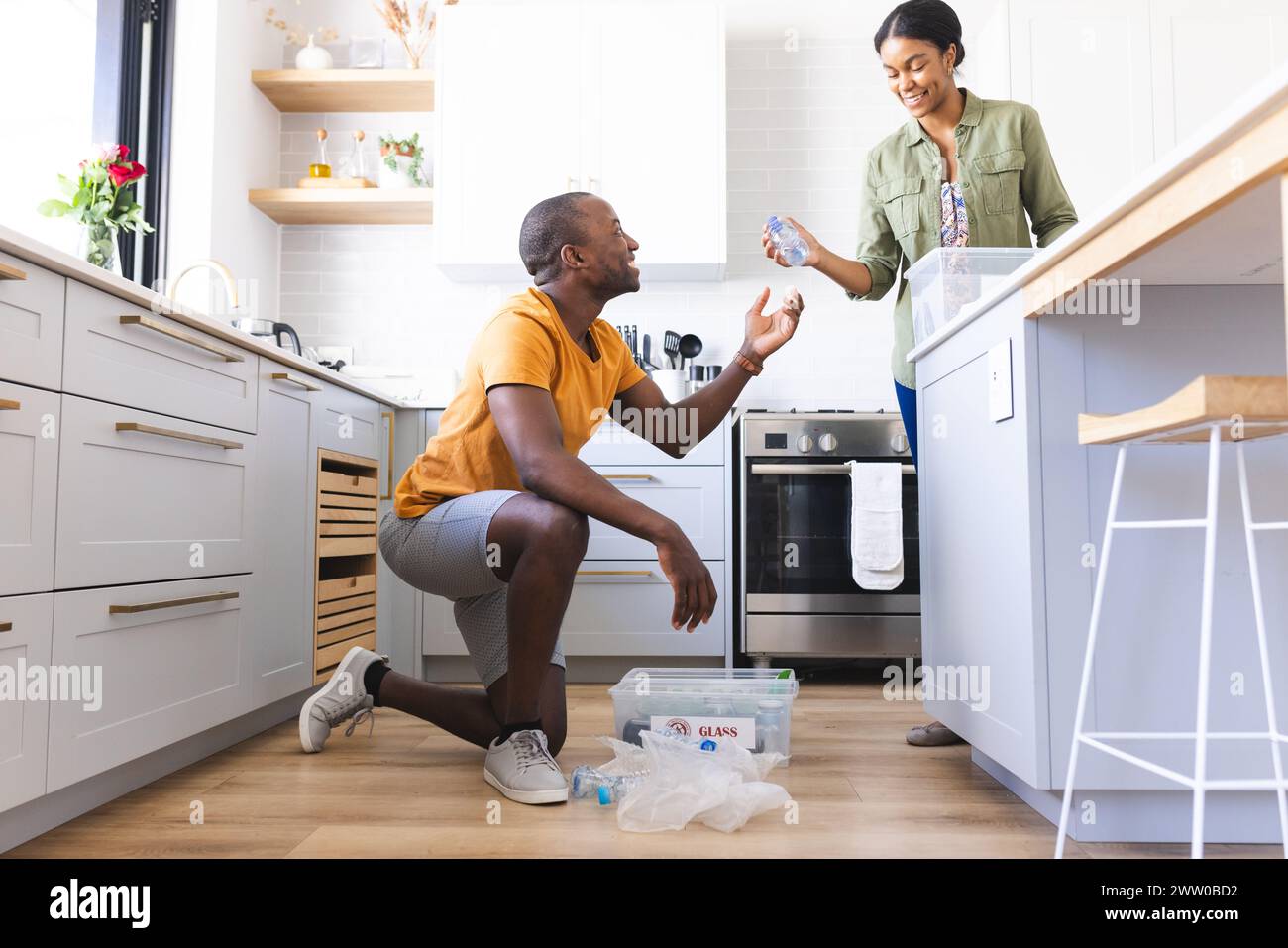 Un couple diversifié est dans le recyclage de cuisine à la maison Banque D'Images
