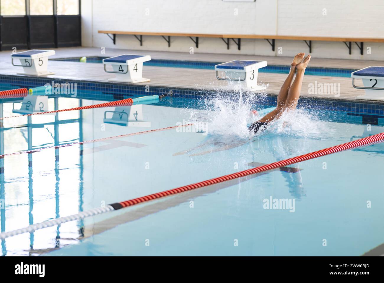 Une personne plonge dans une piscine, créant un éclaboussure avec un espace de copie Banque D'Images