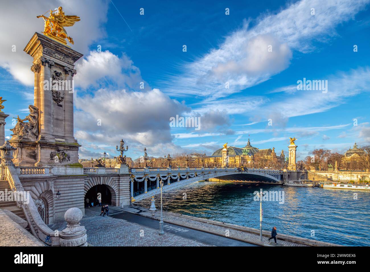 Grand pont à Paris, Pont Alexandre III, avec une statue majestueuse au sommet, enjambant un plan d'eau. Banque D'Images