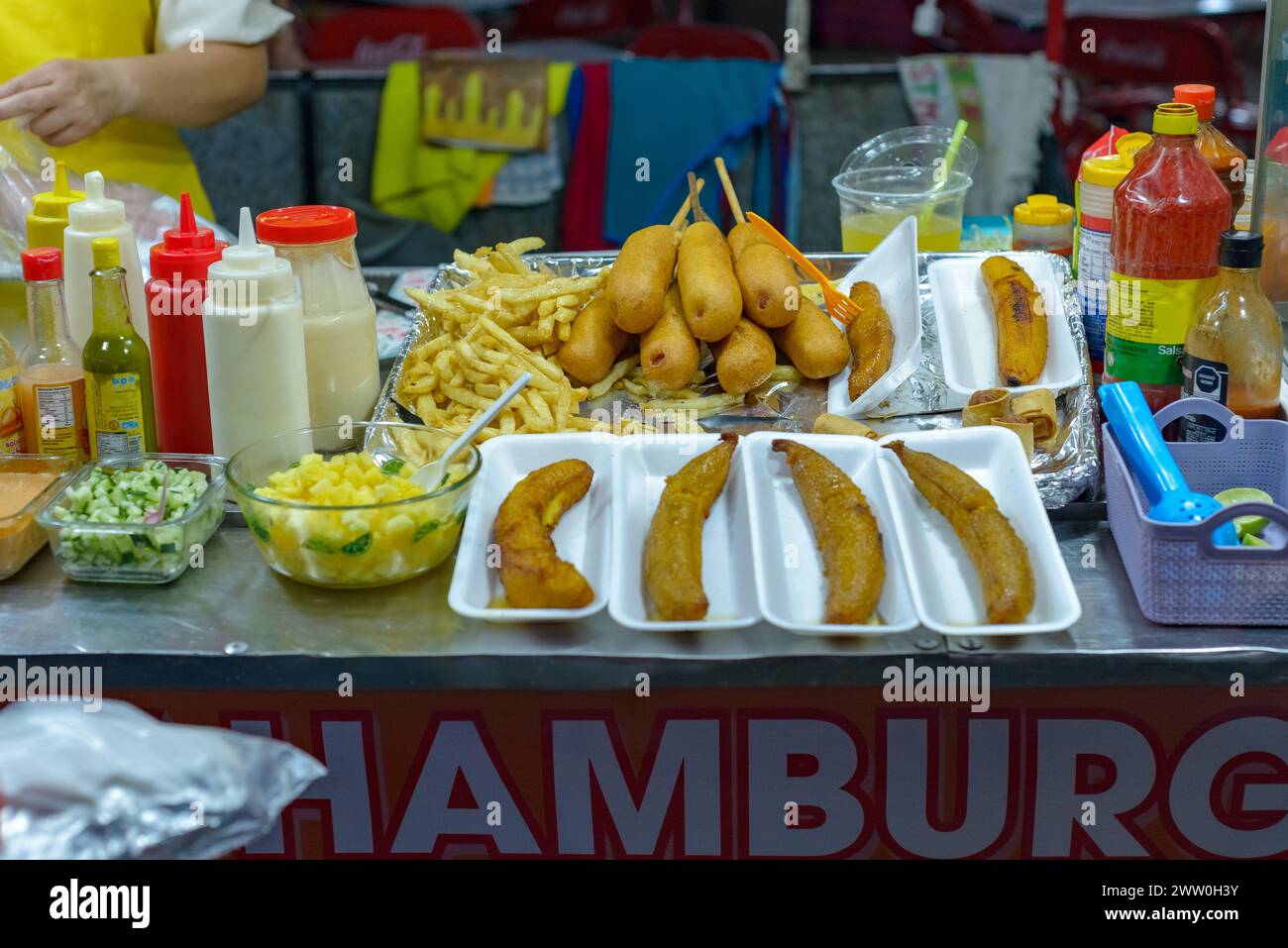 Saucisses, brochettes, pommes de terre, plantains, restauration rapide sur un stand à une foire mexicaine. Banque D'Images