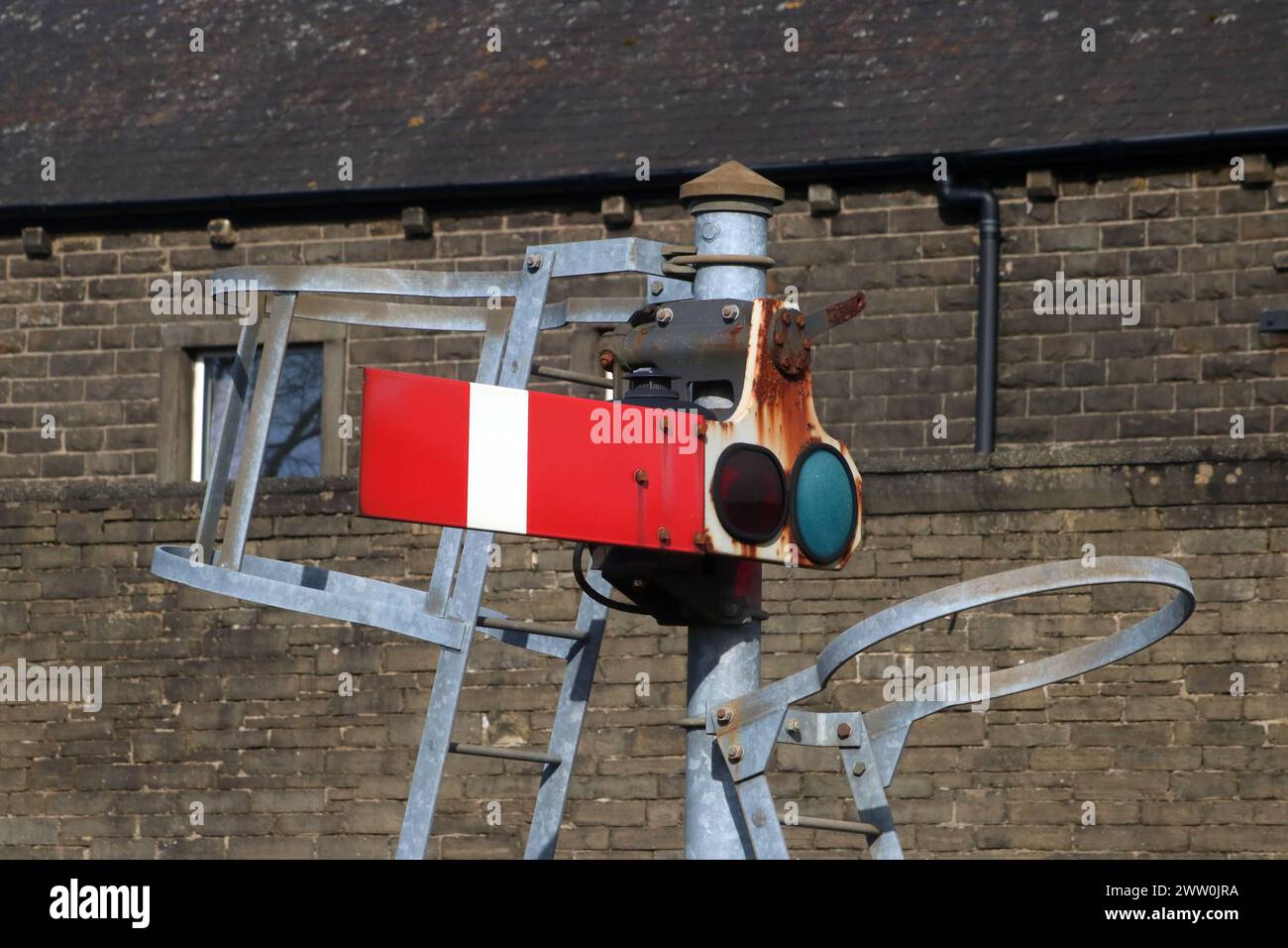 Bras du signal sémaphore rouge en position d'arrêt situé à l'extrémité du quai 1 à la gare de Carnforth. Banque D'Images