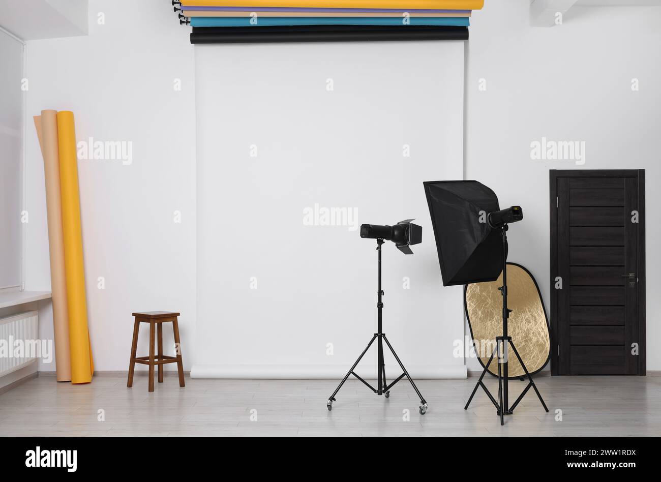 Différents fonds de photo, tabouret et équipement d'éclairage professionnel en studio Banque D'Images