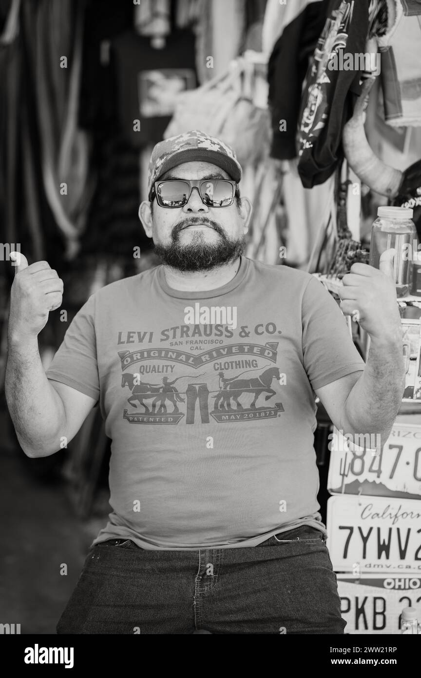 Touristes et marchands de rue dans la rue à Los Algodones Mexique, connu localement comme Molar City. Image en noir et blanc. Banque D'Images