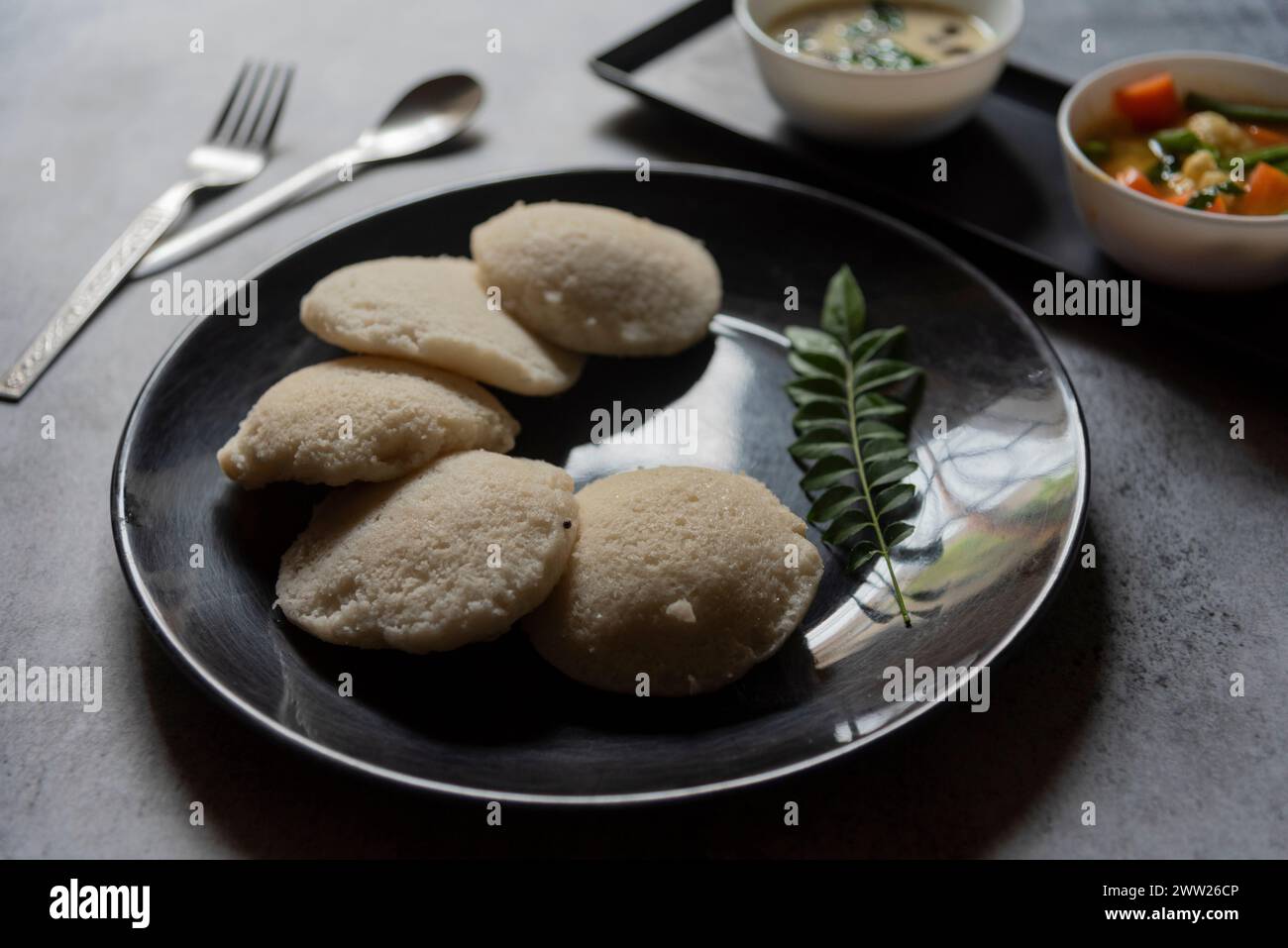 Snacks sud-indiens idli sambar ou idly sambhar préparé à la vapeur de riz fermenté et servi avec trempette à la noix de coco et soupe de légumes ou sambar. Banque D'Images