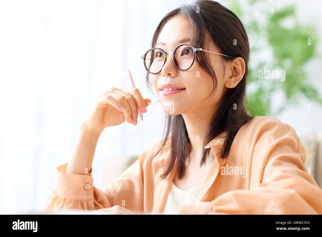 Une femme en lunettes assise à un bureau Banque D'Images