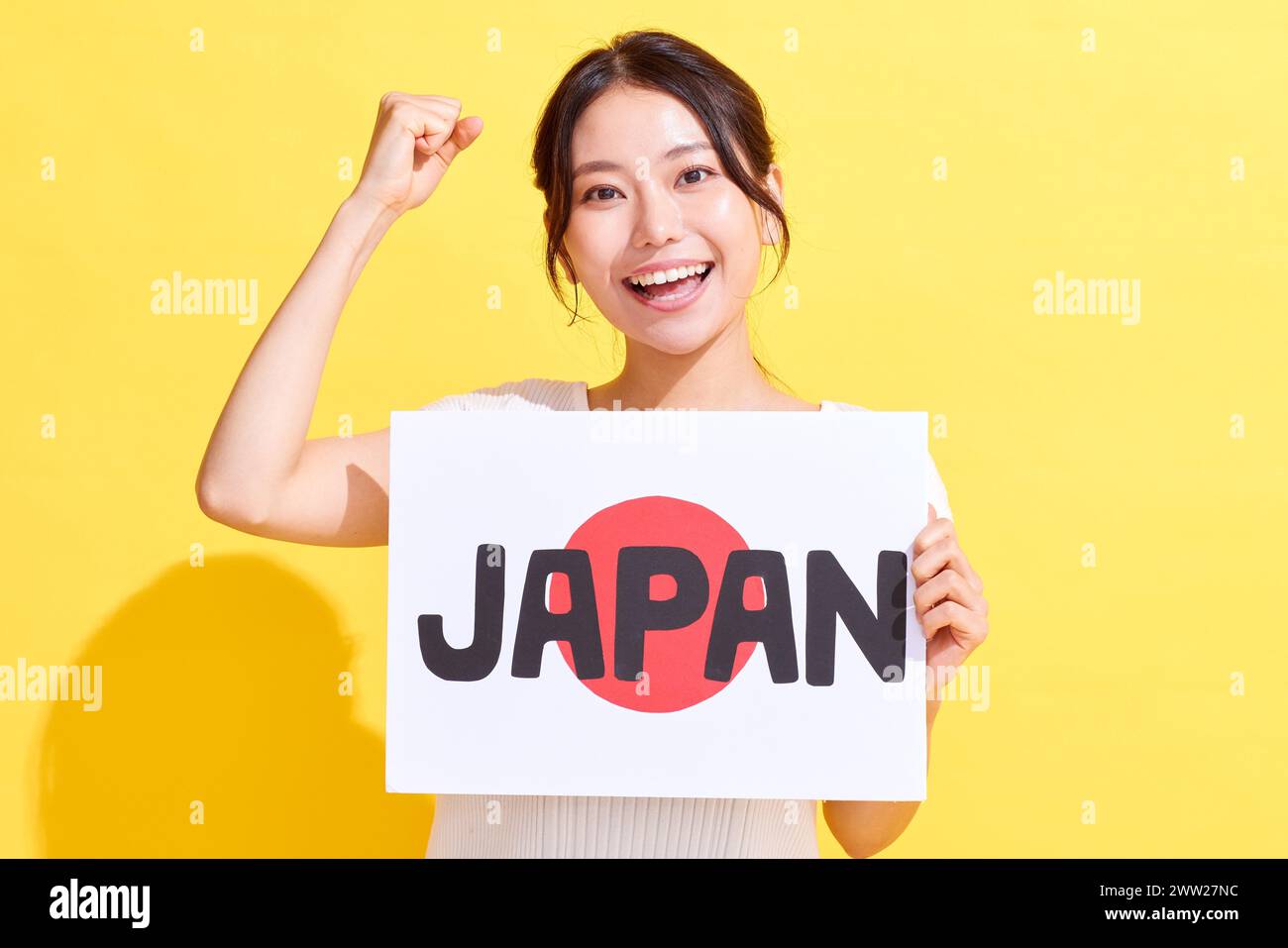 Femme japonaise tenant un tableau blanc et acclamant Banque D'Images
