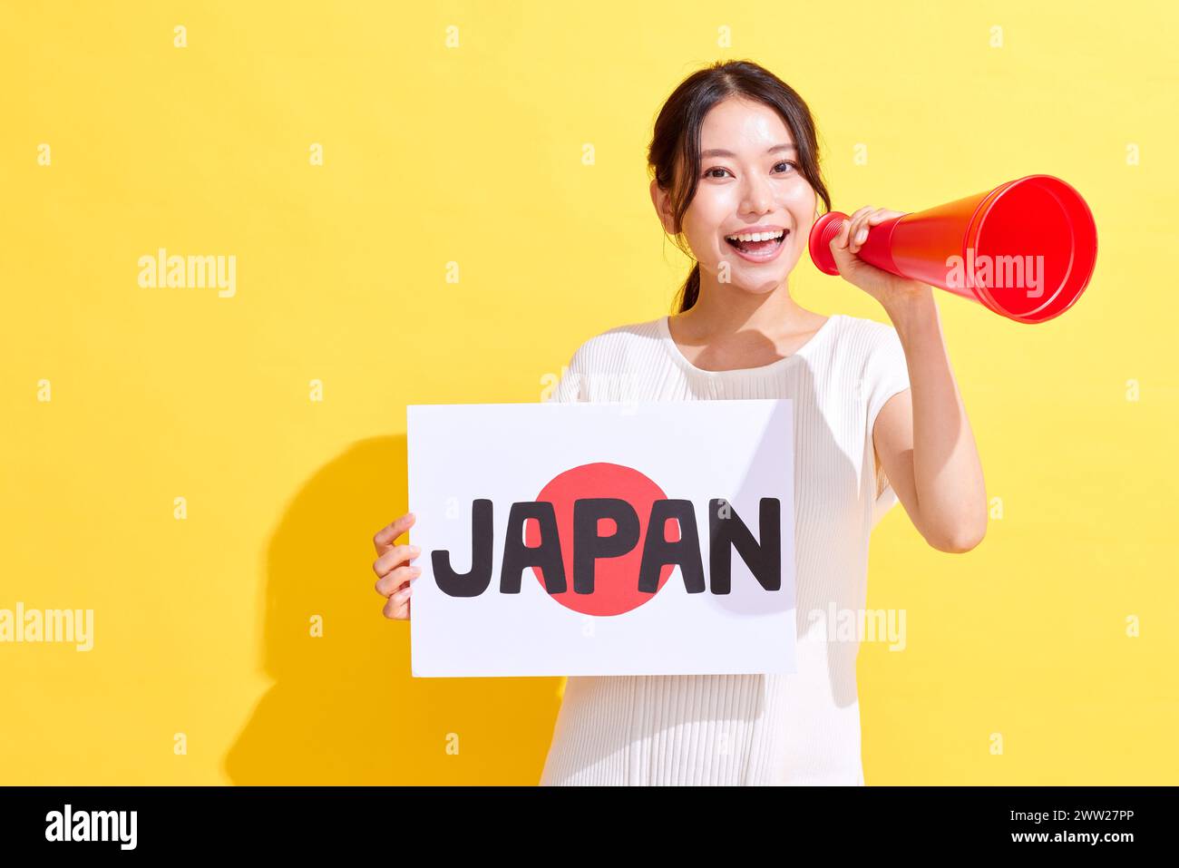 Femme japonaise tenant une pancarte avec le mot Japon et un mégaphone Banque D'Images