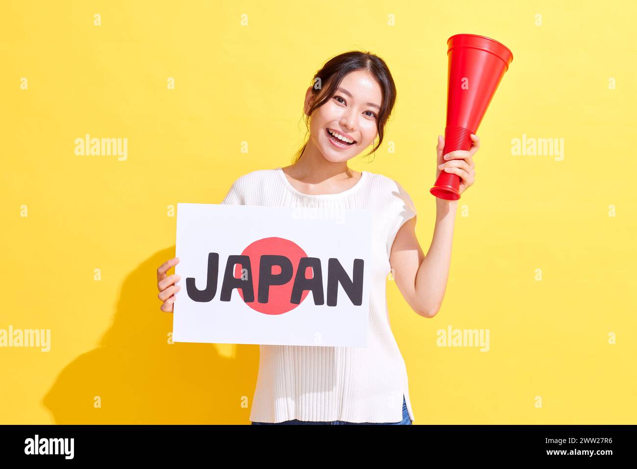 Femme japonaise tenant une pancarte avec du texte japonais et un mégaphone Banque D'Images