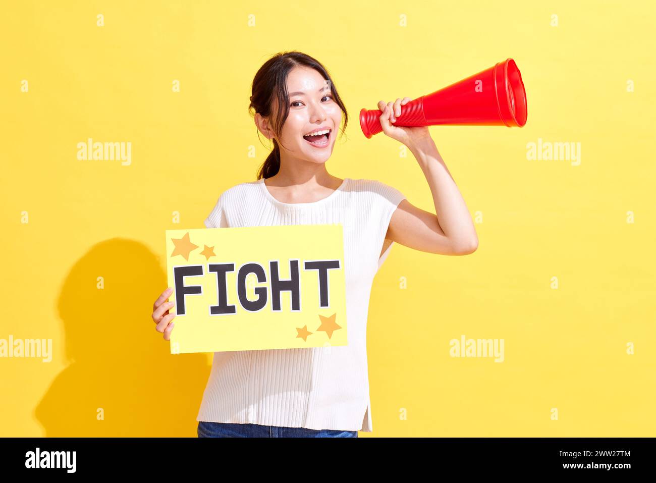 Femme tenant un signe de combat et criant dans un mégaphone Banque D'Images