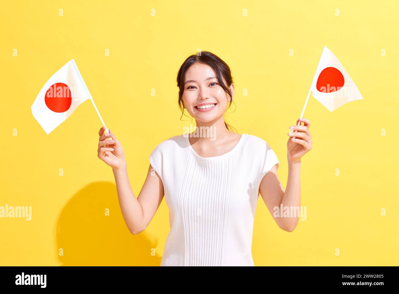 Femme asiatique tenant des drapeaux japonais Banque D'Images