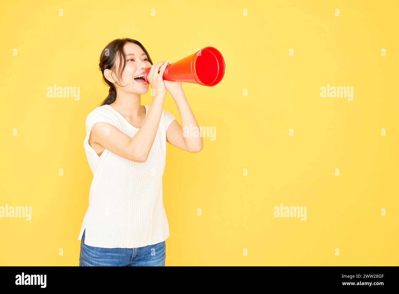 Une femme criant dans un mégaphone rouge Banque D'Images