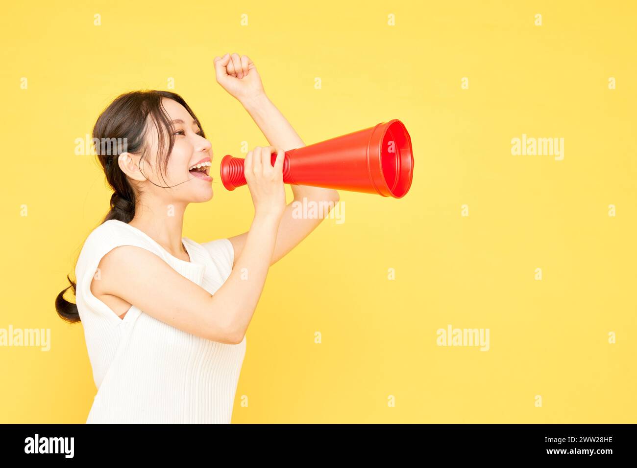 Une femme criant dans un mégaphone rouge Banque D'Images