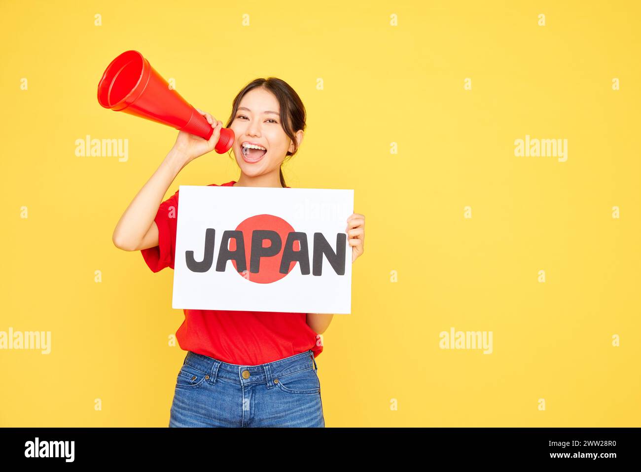 Femme japonaise tenant un panneau avec le mot Japan et un mégaphone sur fond jaune Banque D'Images