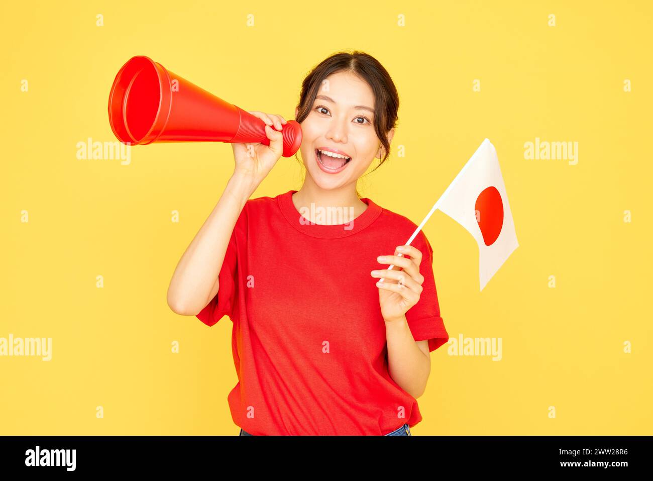 Femme asiatique tenant un drapeau japonais et criant dans un mégaphone Banque D'Images