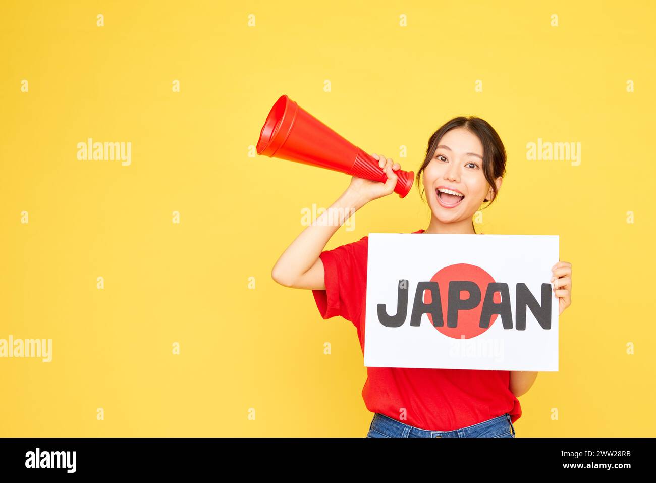 Femme japonaise tenant un panneau avec le mot Japan et un mégaphone sur fond jaune Banque D'Images
