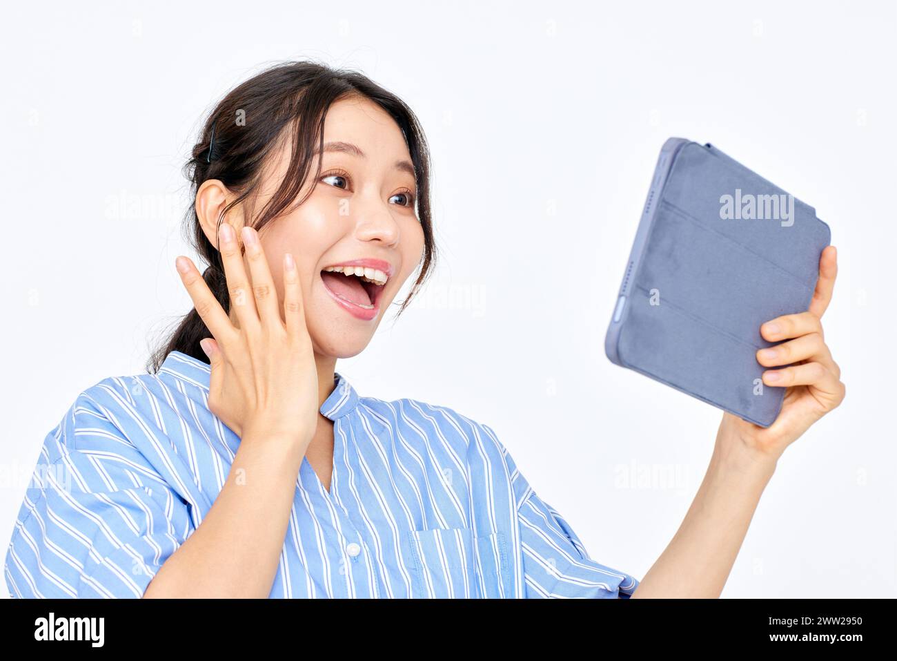 Une femme tenant une tablette et ayant l'air surprise Banque D'Images