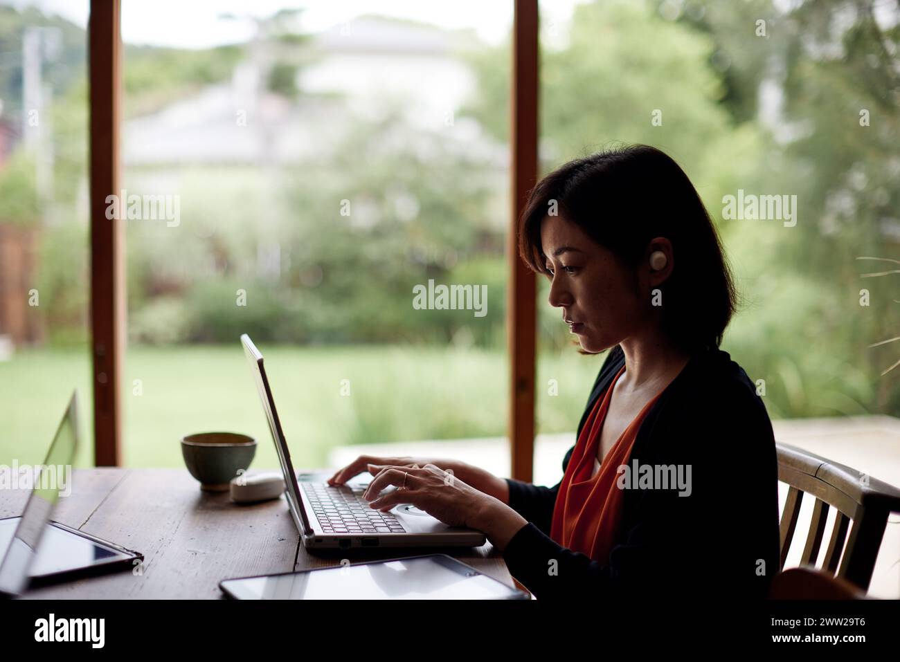 Une femme assise à une table avec un ordinateur portable Banque D'Images