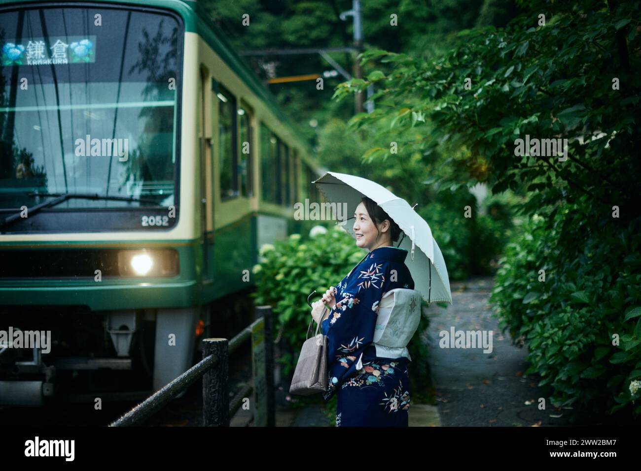 Une femme en kimono se tient à côté d'un train Banque D'Images
