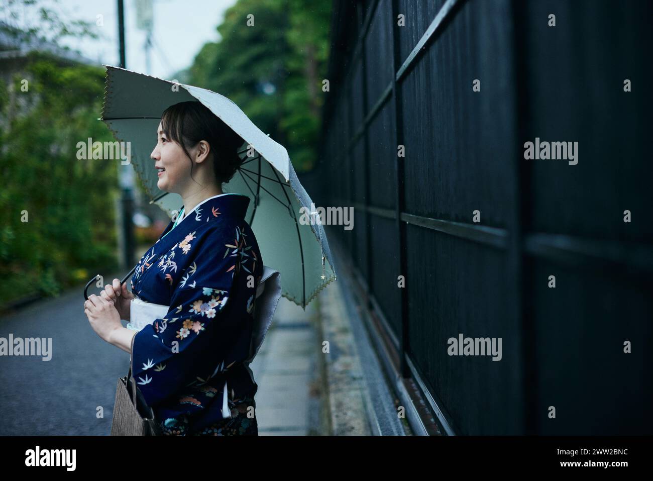 Une femme en kimono tenant un parapluie Banque D'Images