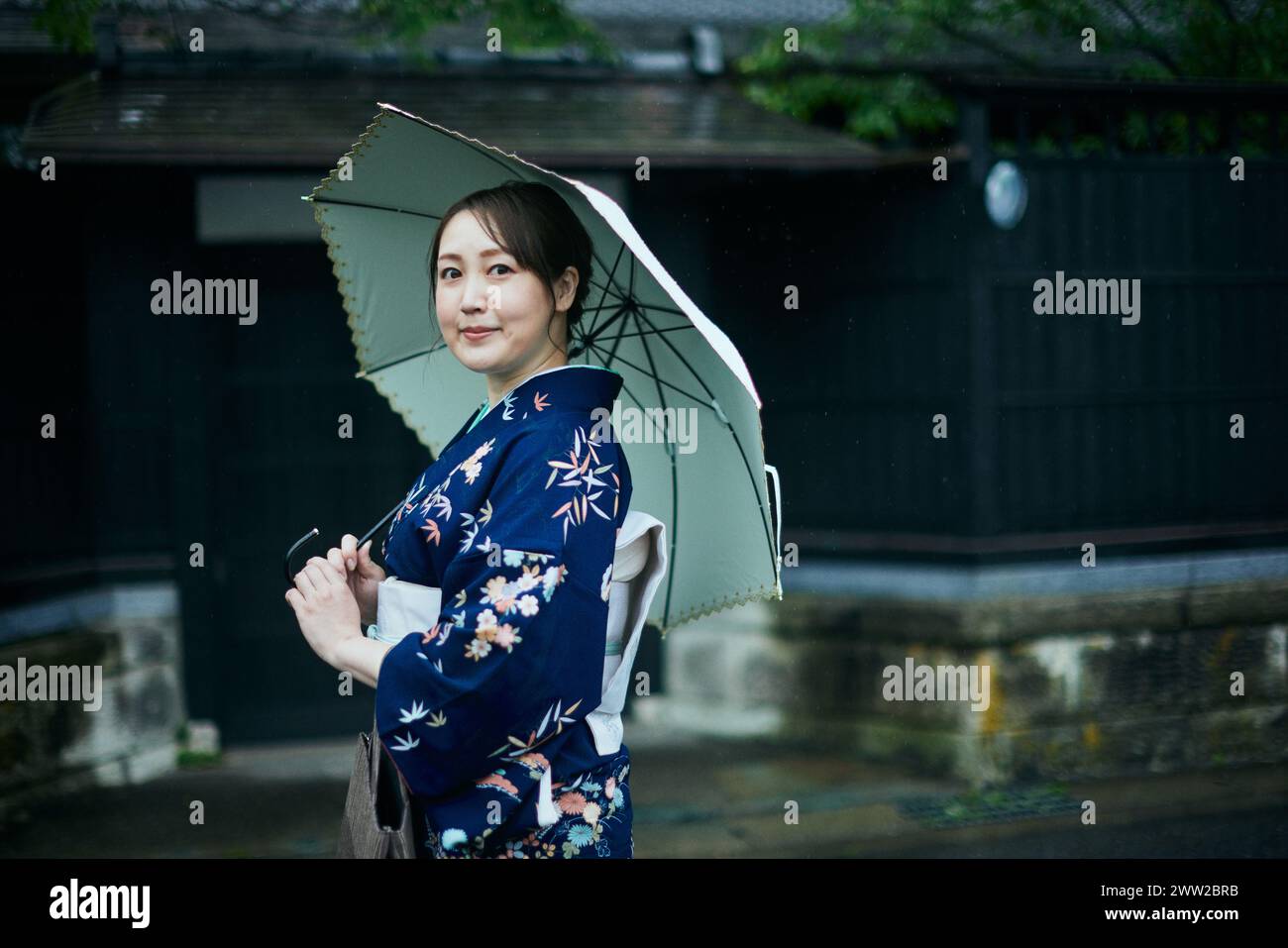 Une femme en kimono tenant un parapluie Banque D'Images