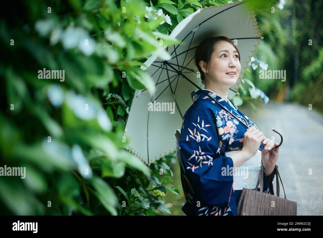 Une femme en kimono tenant un parapluie Banque D'Images