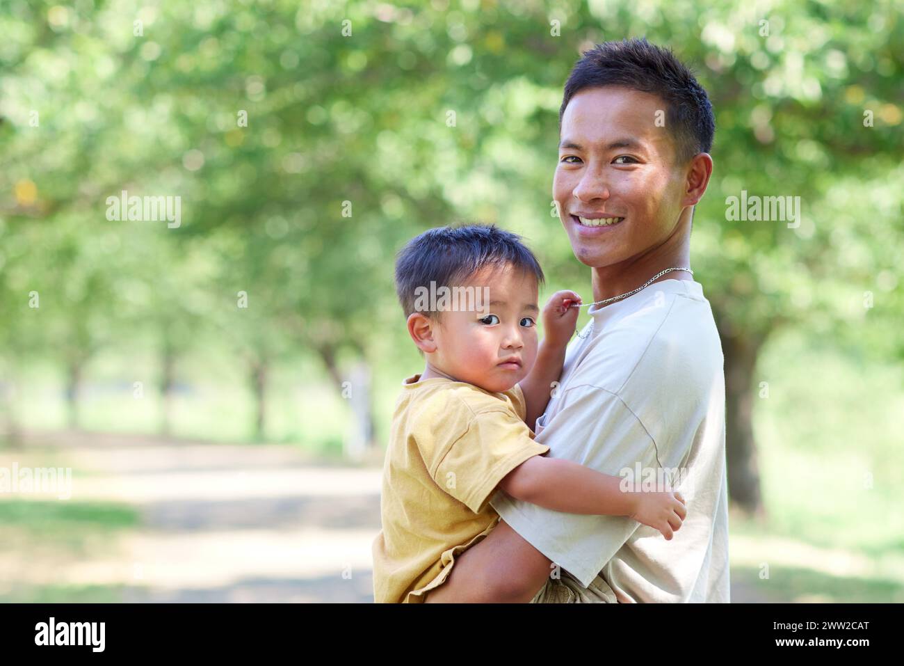 Un homme tenant un enfant dans ses bras Banque D'Images
