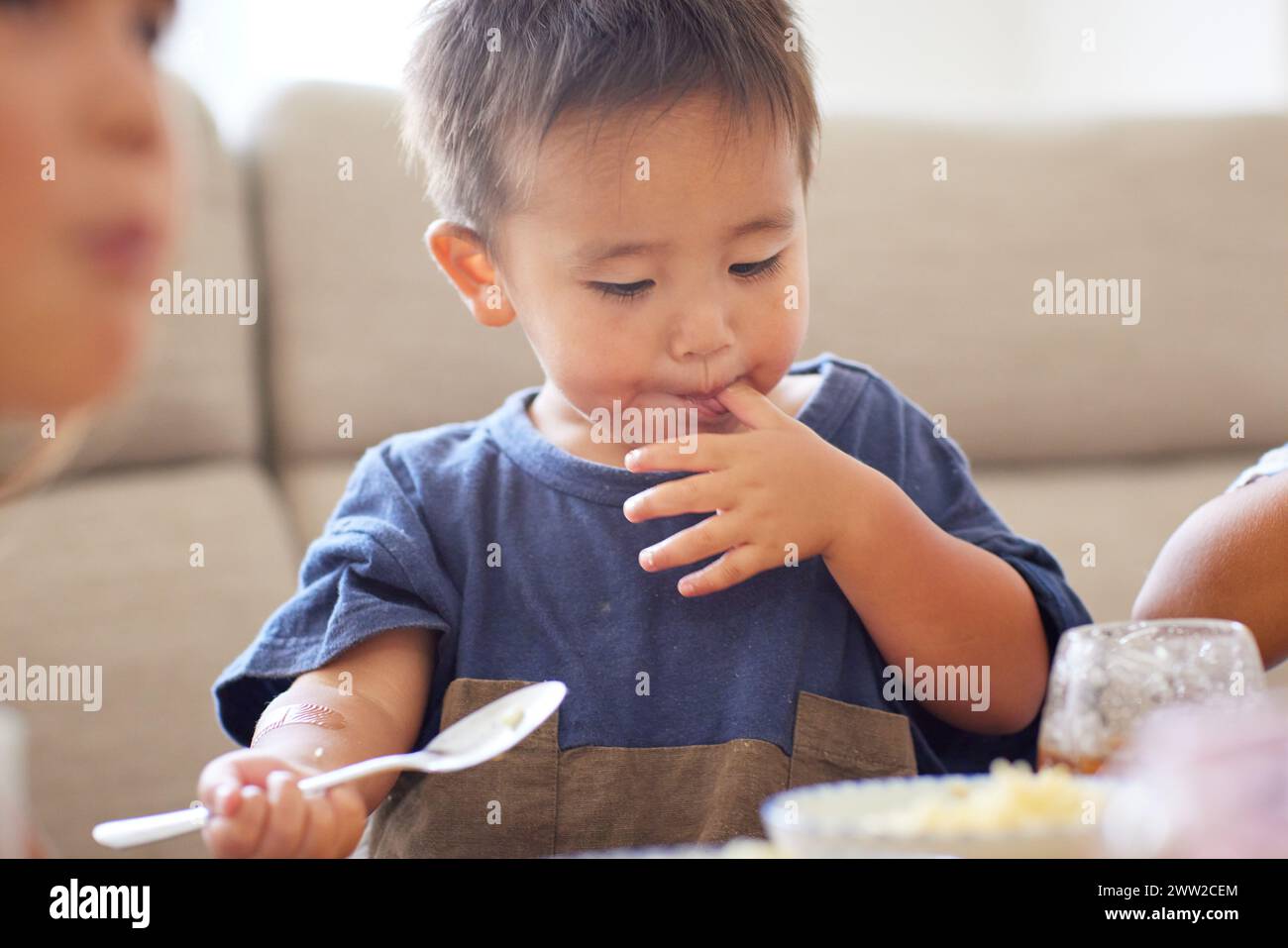 Enfant assis à une table mangeant de la nourriture Banque D'Images