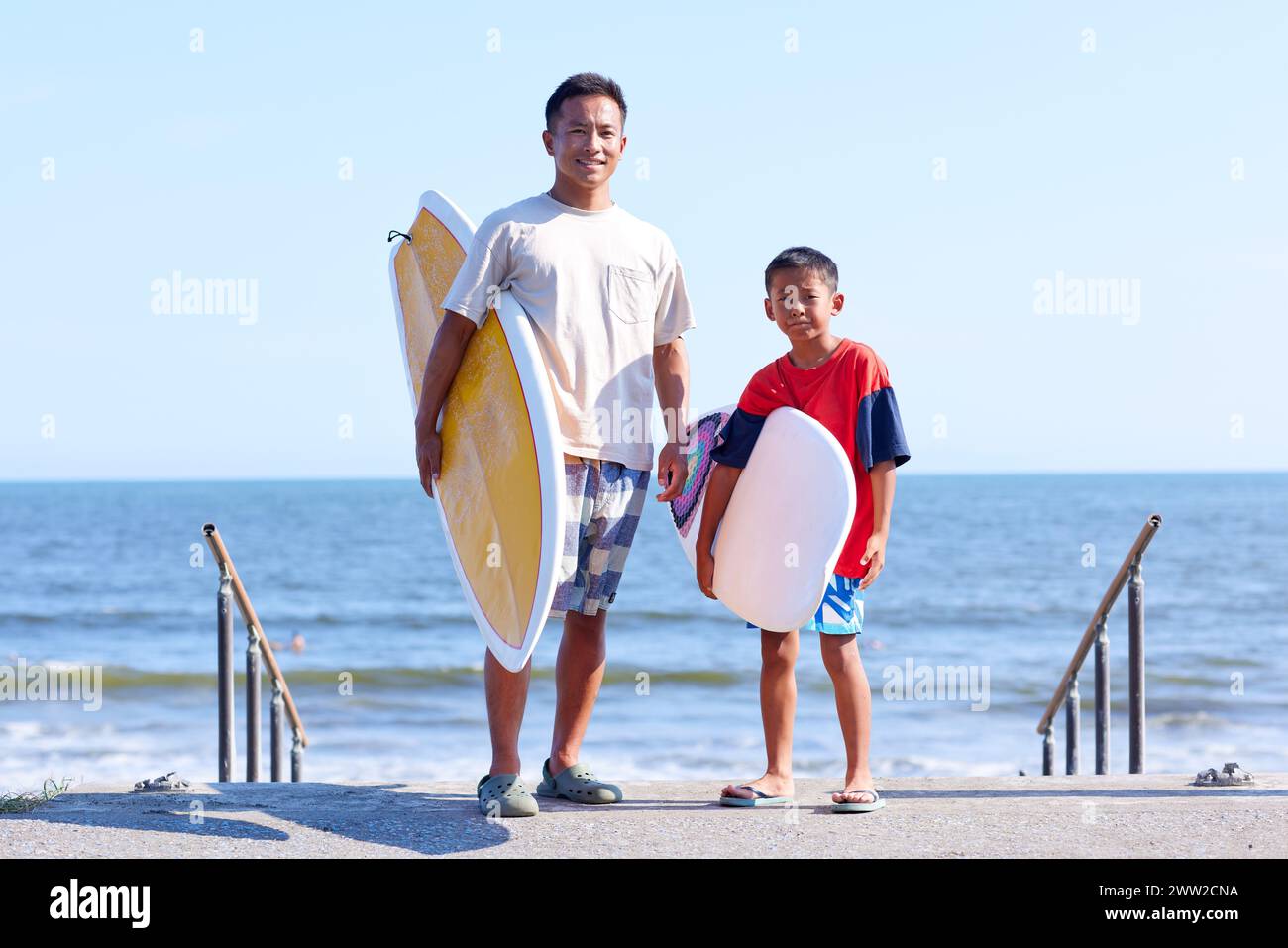 Famille avec planches de surf à la plage Banque D'Images