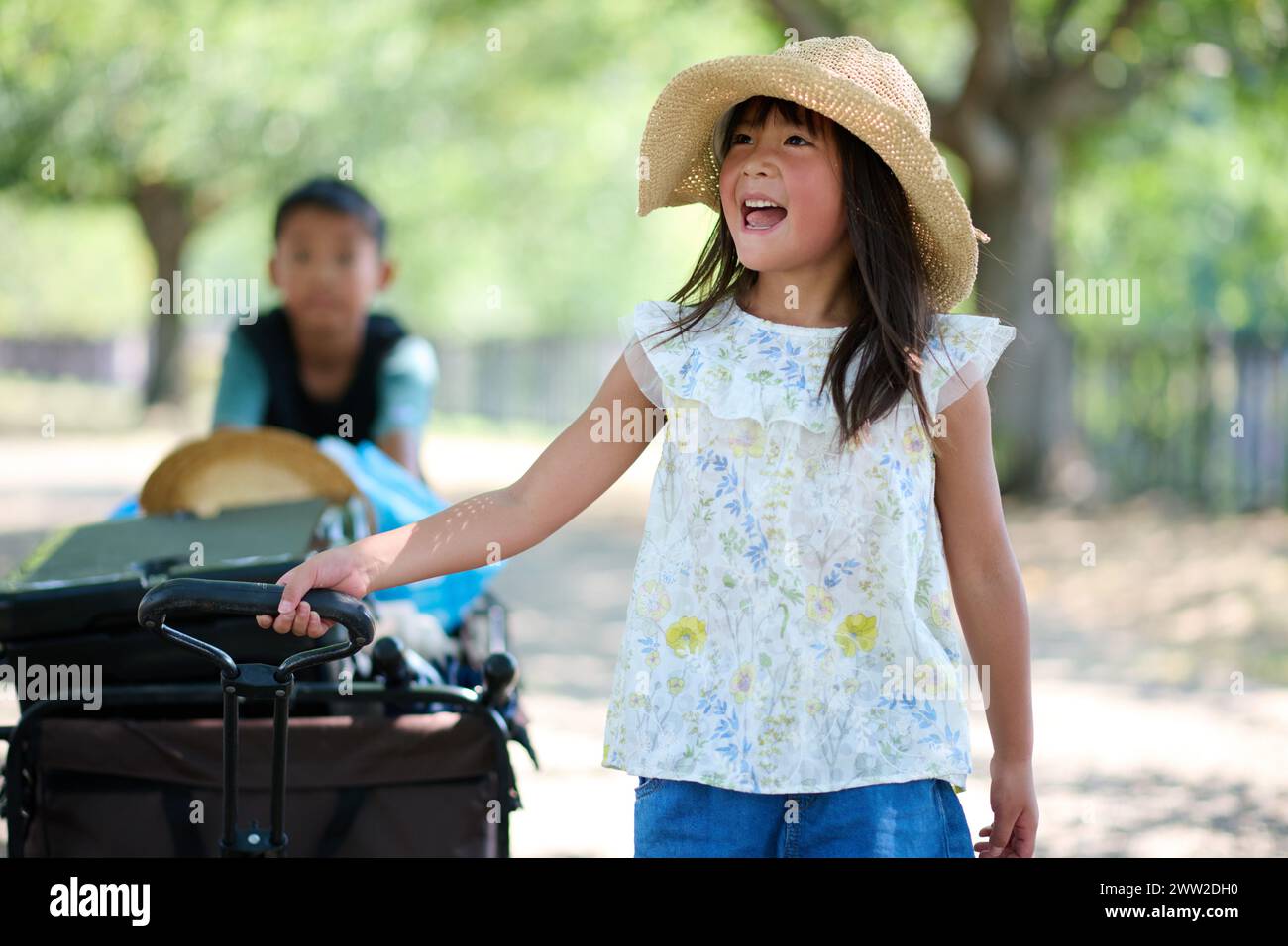Une petite fille avec un chapeau et une charrette Banque D'Images