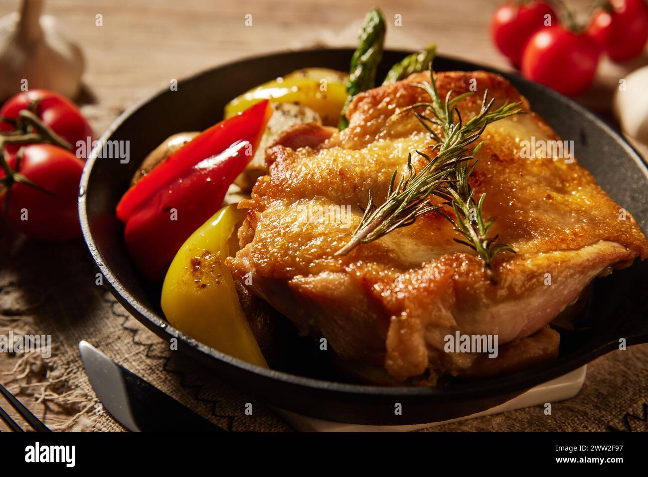 Une poêle avec des légumes de poulet et des tomates Banque D'Images