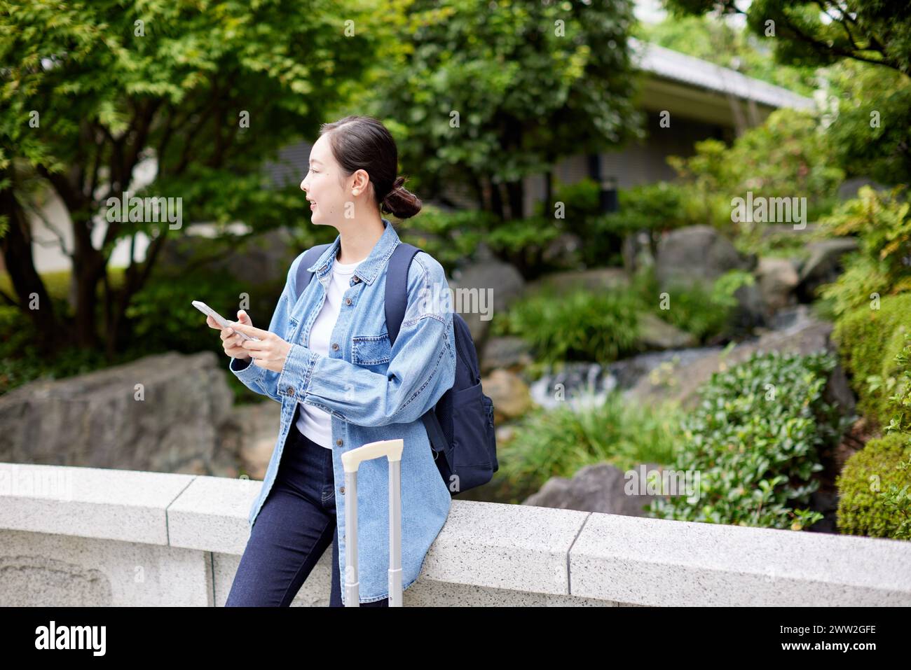 Une femme avec une valise et un téléphone portable Banque D'Images