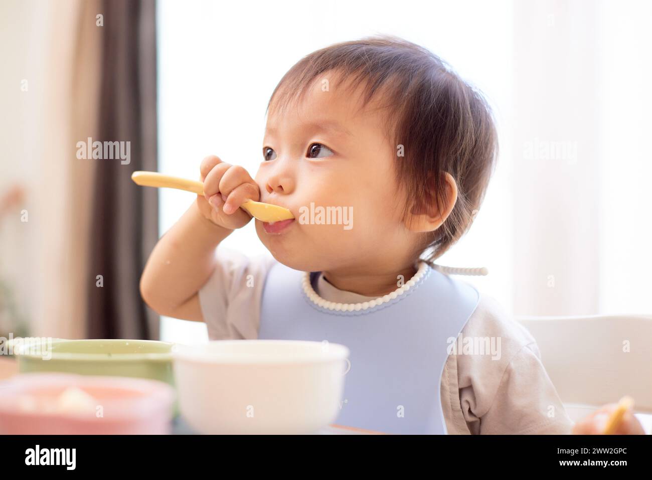 Un bébé mangeant une cuillerée de nourriture Banque D'Images
