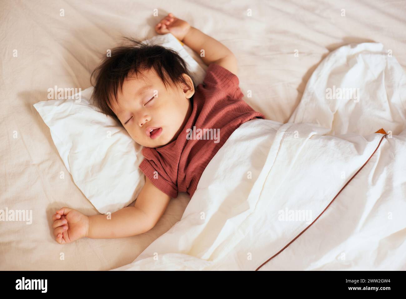 Bébé asiatique dormant au lit Banque D'Images