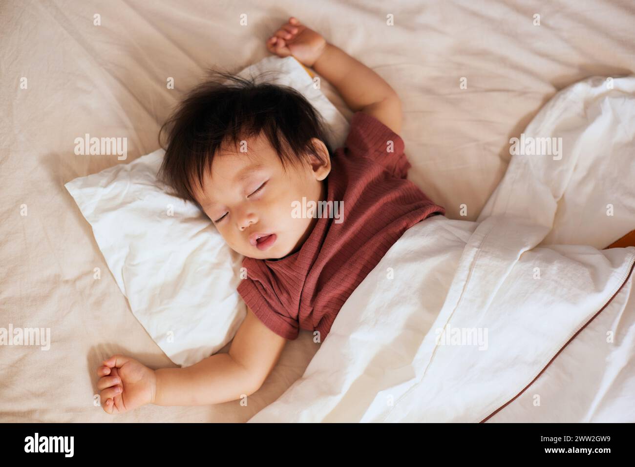 Bébé asiatique dormant au lit Banque D'Images